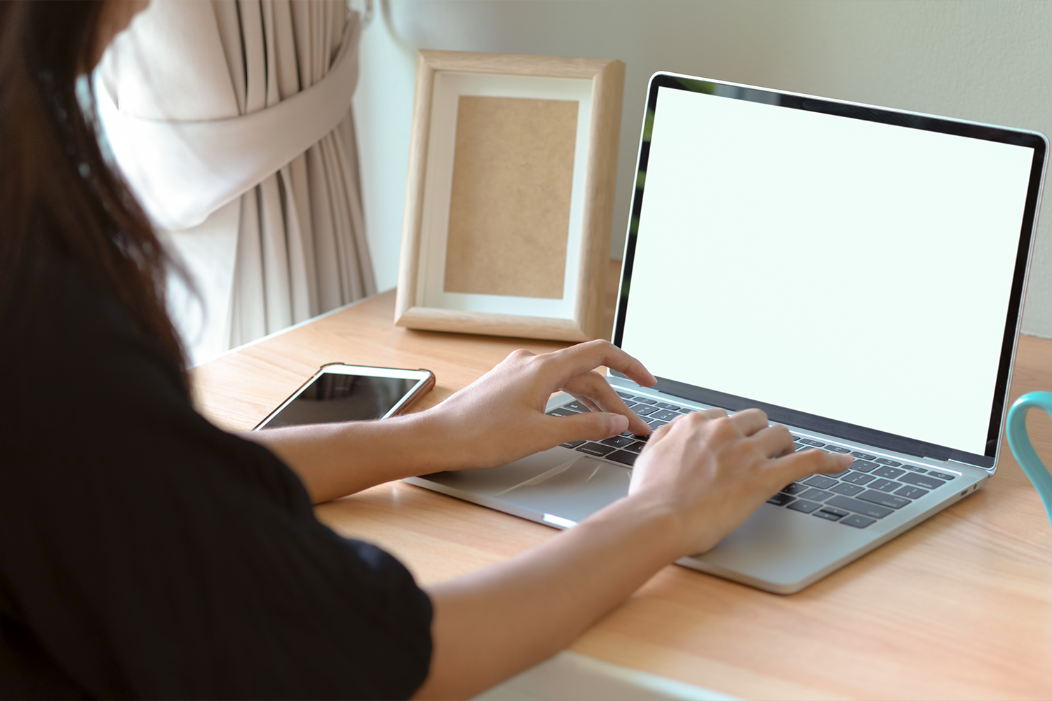 Hands typing on a laptop