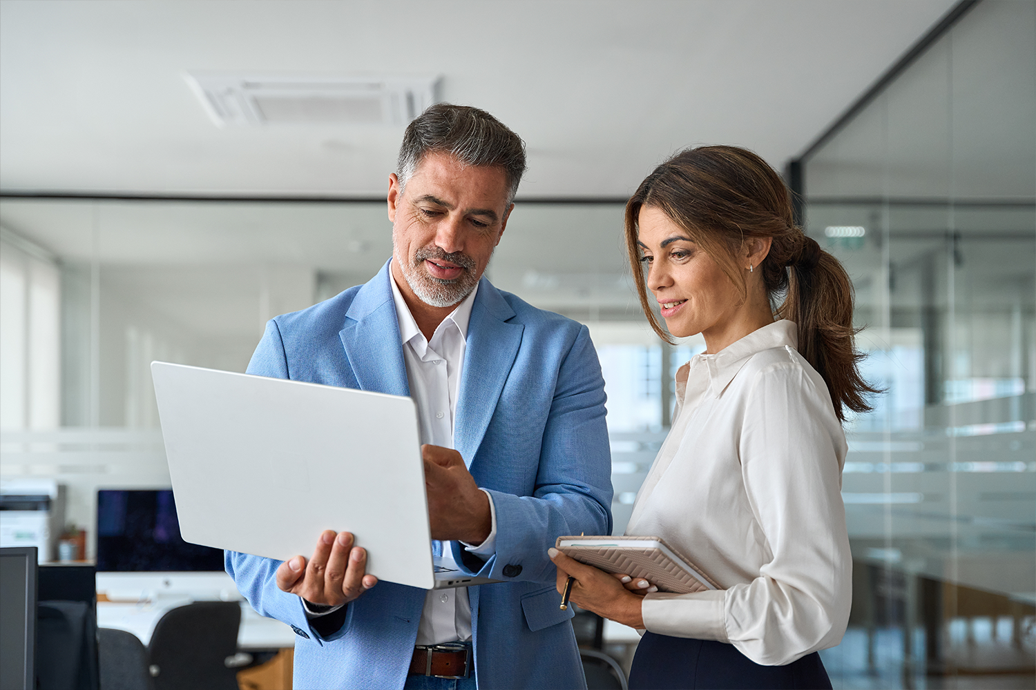 A man and a woman standing with a laptop