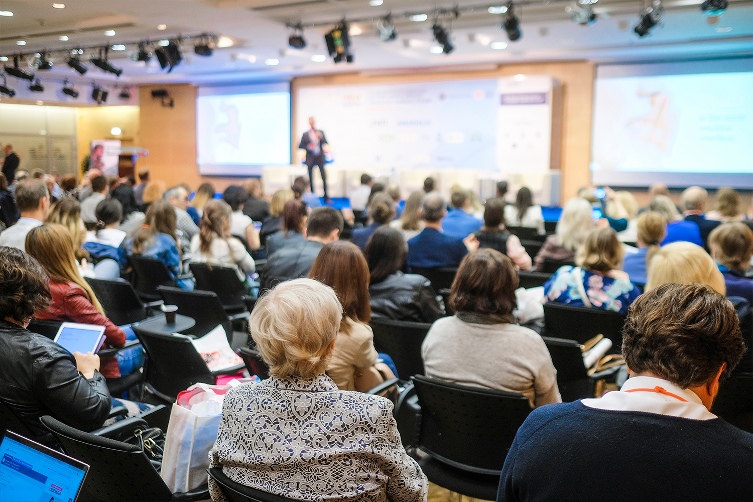 Many people in an auditorium listening to a presentation